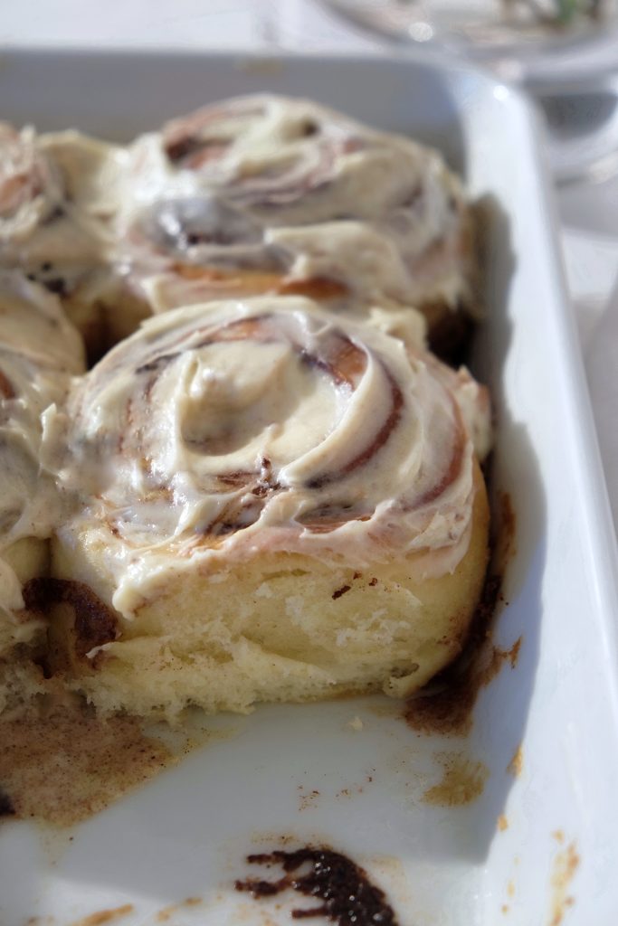 Cinnamon rolls fresh out of the oven and topped with cream cheese frosting