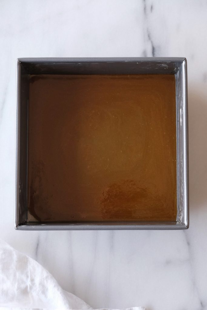 Melted butter and brown sugar mixture in a square baking pan
