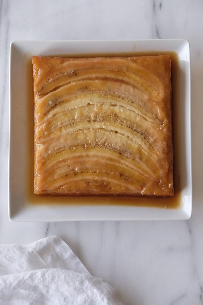 Caramelized banana upside down cake on a square ceramic plate