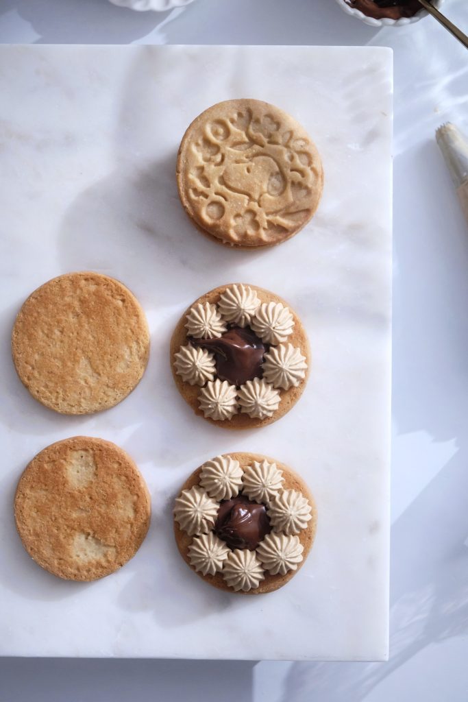 Assembling 6 Piemonte hazelnut cookie sandwich halves into 3 sandwiches