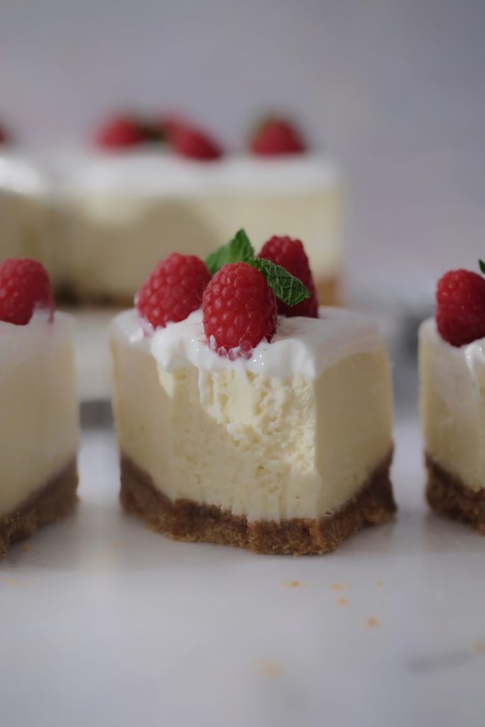Slices of New York cheesecake with sour cream topping