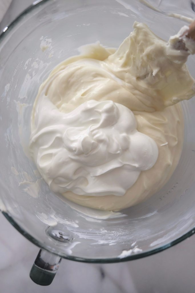 Glass bowl with cheesecake batter sour cream